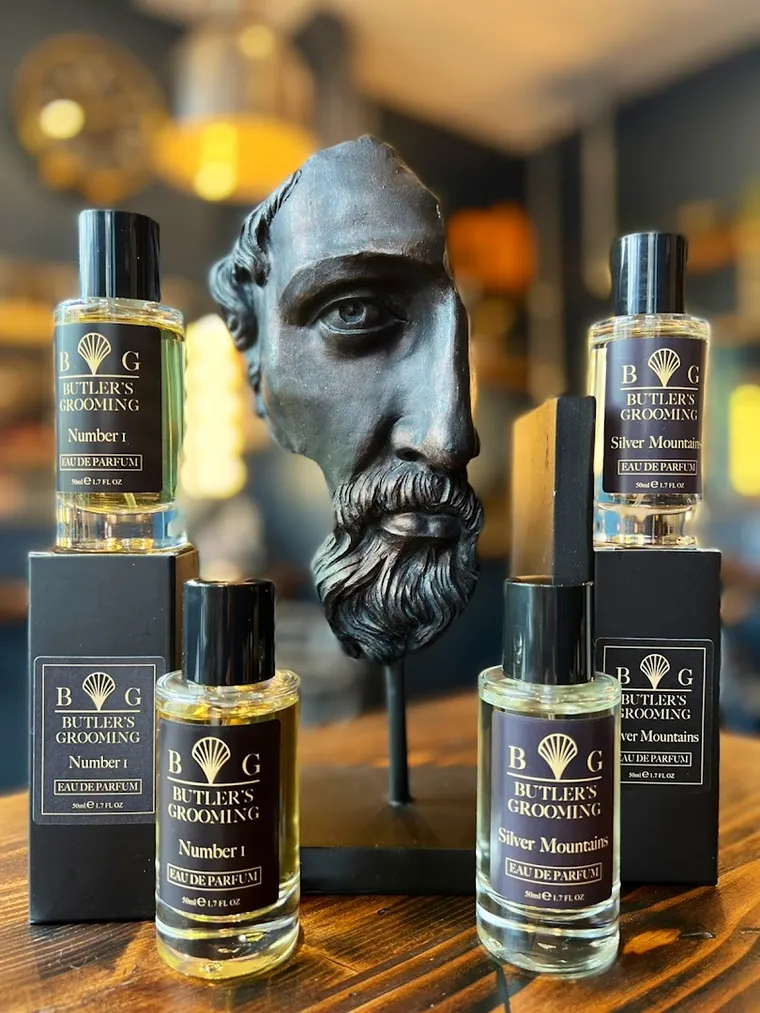 Butler’s Grooming eau de parfum bottles on the shop counter beside a bronze bust